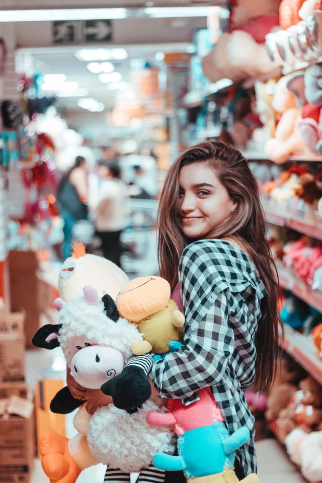Girl Holding Colorful Plush Toys and Stuffed Animals for Children
